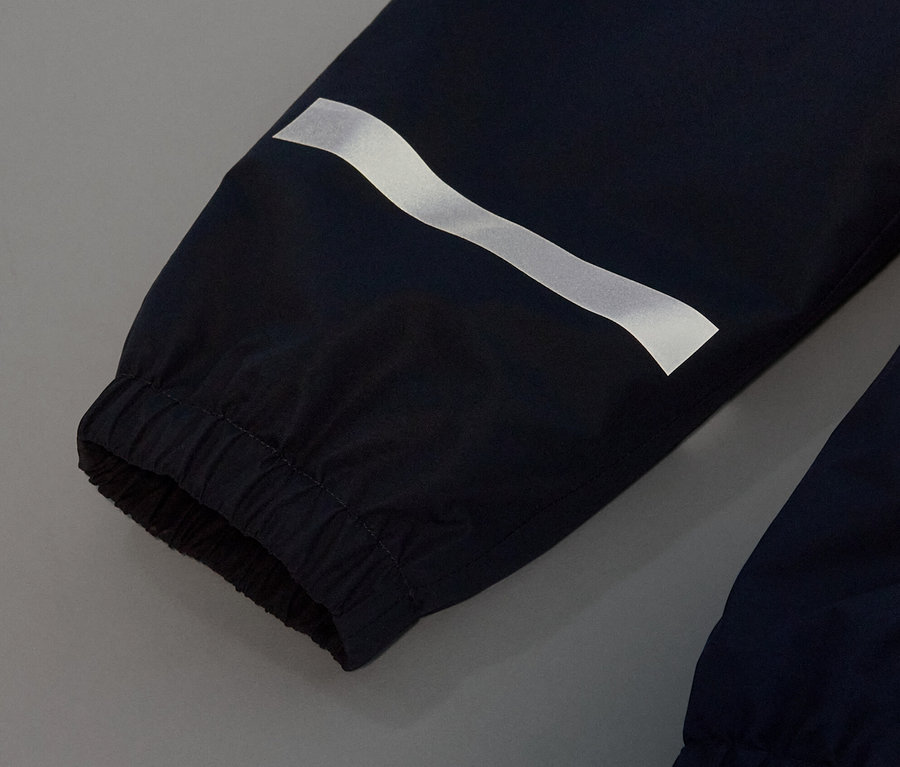 Detailaufnahme einer dunkelblauen Kinder-Regenhose mit reflektierendem Streifen.