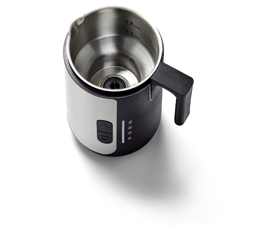 Detail eines Milchaufschäumers mit Griff, der das Innere des Edelstahlbehälters zeigt.