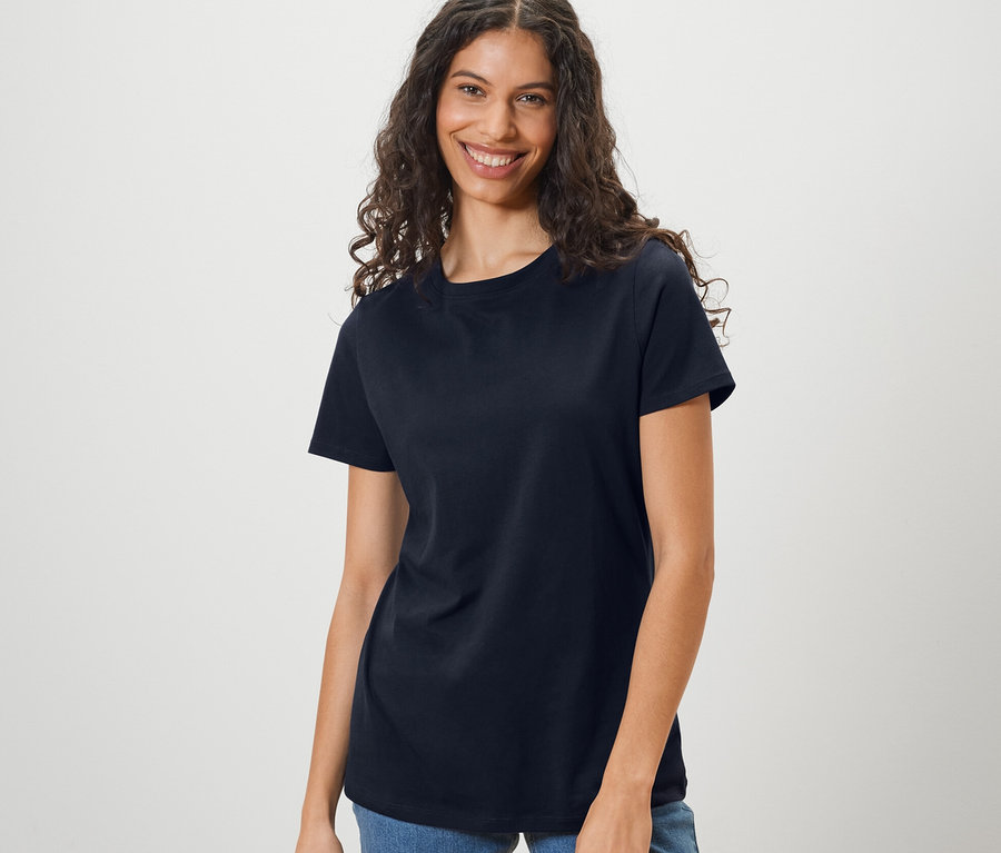 Frau trägt ein dunkelblaues Basic T-Shirt und Jeans.