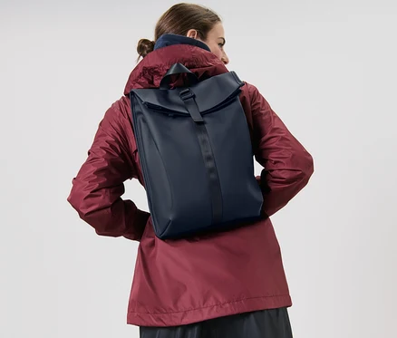 Frau trägt Regenrucksack.