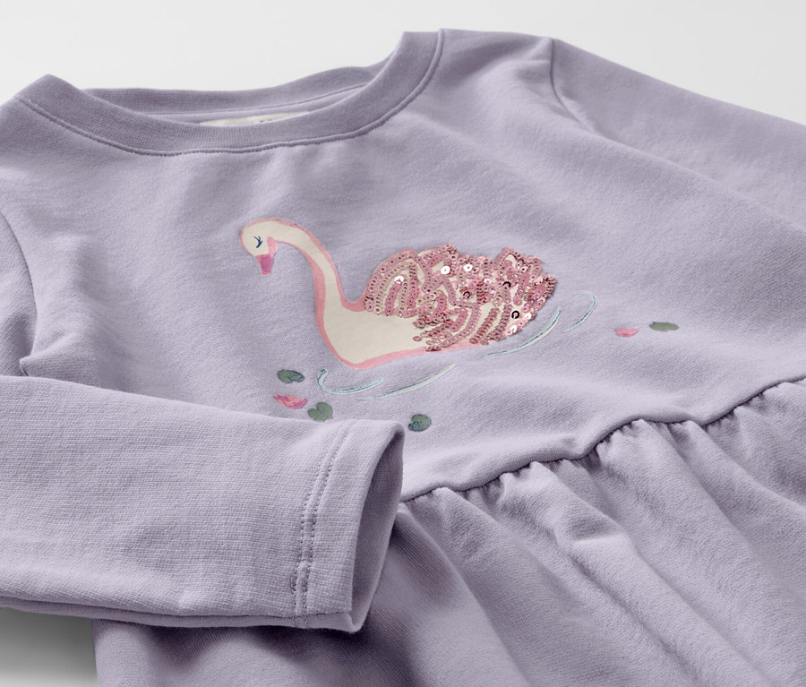 Lila Kinder-Sweatkleid mit Schwan-Applikation aus Pailletten.