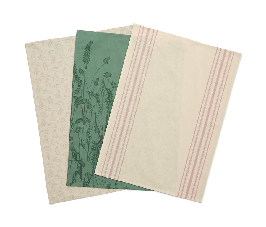 Drei Geschirrtücher: Eines mit Kaninchenmuster, eines mit grünem Grasmuster und eines mit rosa Streifen.