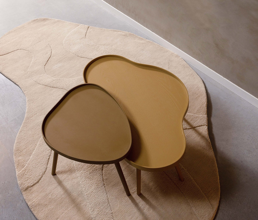 Zwei Woood Mae Beistelltische in Alpaka Farbe auf einem beige Teppich.