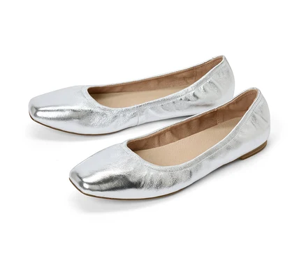 Zwei silberne Leder-Ballerinas liegen nebeneinander auf einem weißen Hintergrund.