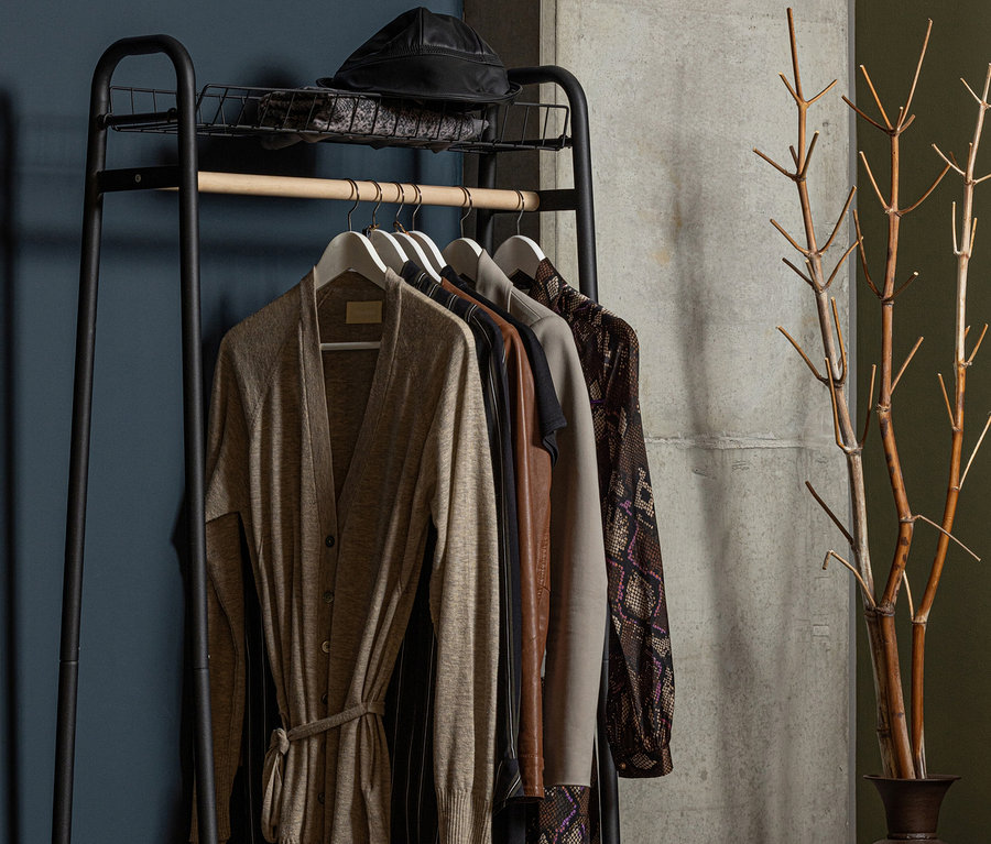 Schwarzer Woood Metall-Kleiderständer Jovi mit Kleidung und Hut.