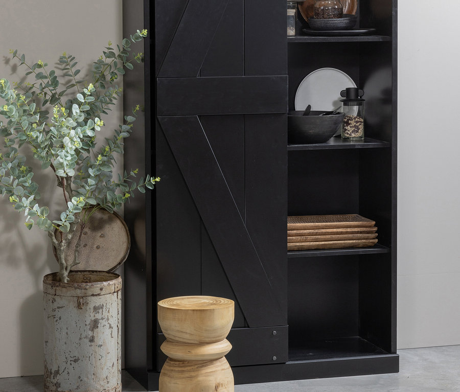 Dekoratives Interieur mit schwarzem Schrank, Pflanze in grauem Behälter und naturfarbenem Woood Hocker »Bikkel«.