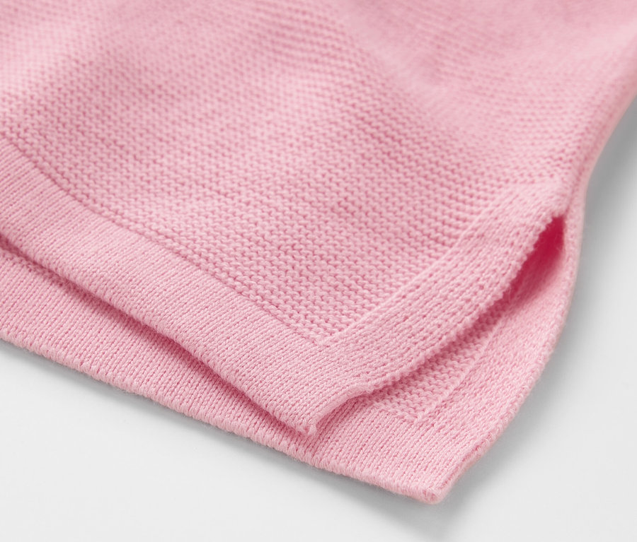 Nahaufnahme eines roséfarbenen Strickpullovers.
