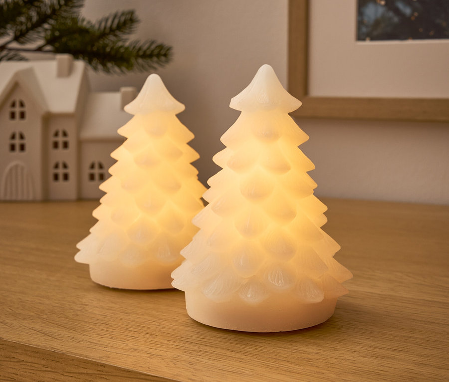 Zwei leuchtende Bäume auf einer Holzoberfläche.