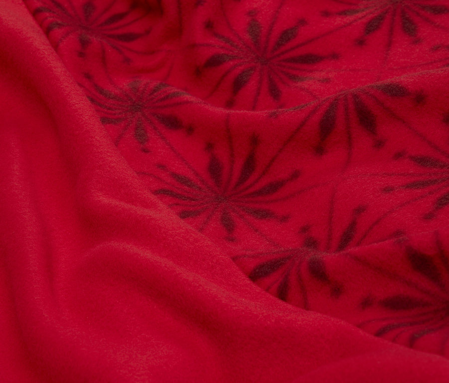 Detailaufnahme eines roten Stoffes mit dunklem Blumenmuster.