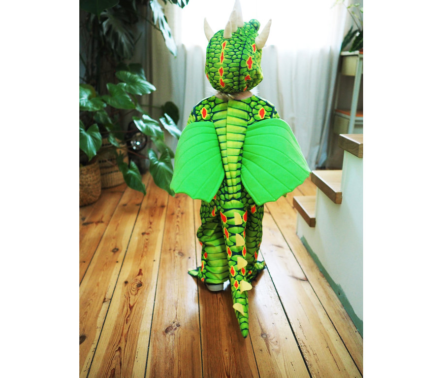 Kind mit dem Rücken zur Kamera trägt ein »Drache«-Kostüm von Small Foot.