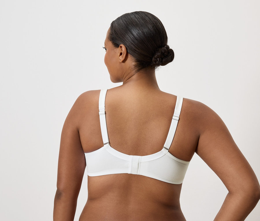 Rückansicht einer Frau mit hochgesteckten Haaren, die einen weißen BH trägt.