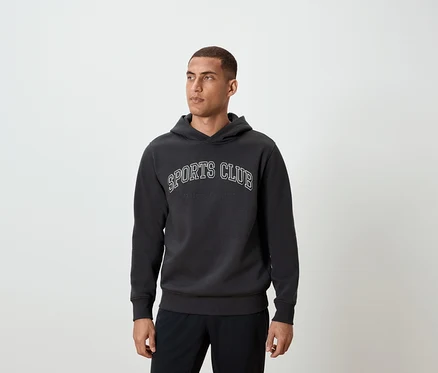Mann trägt einen dunkelgrauen Hoodie mit der Aufschrift SPORTS CLUB.