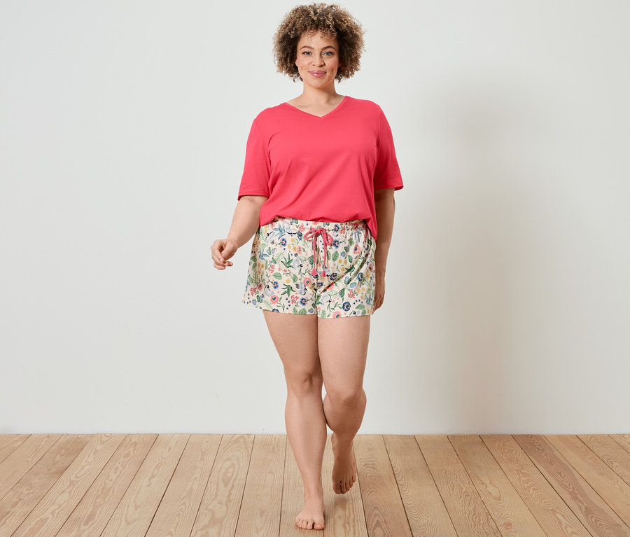 Frau geht und trägt ein Shorty-Pyjama-Set.