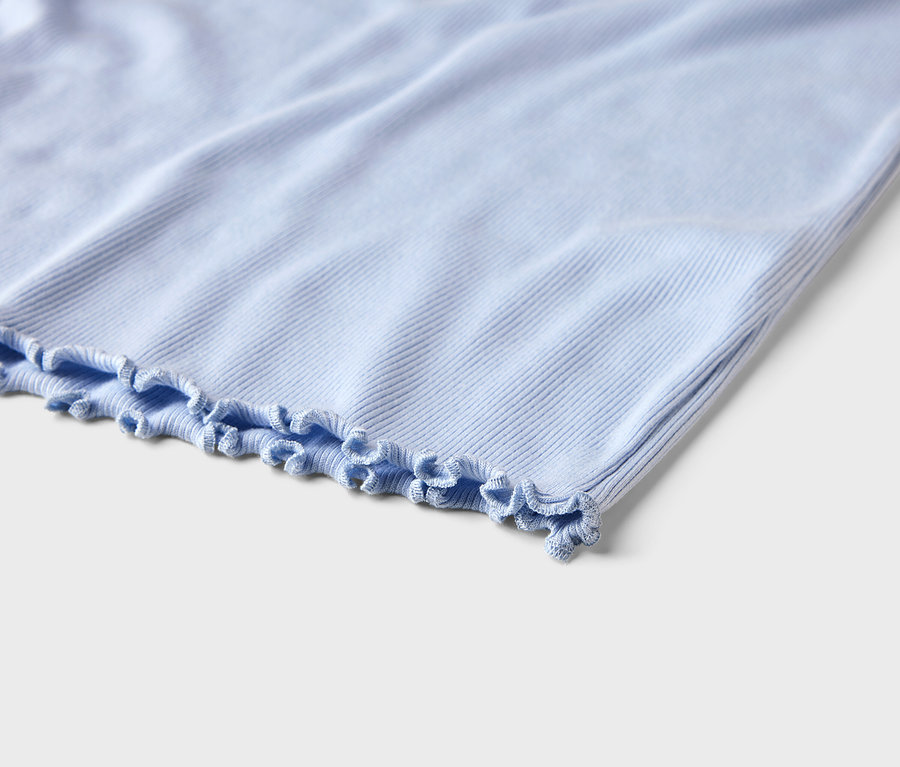 Nahaufnahme eines hellblauen gerippten Stoffes mit Rüschensaum.
