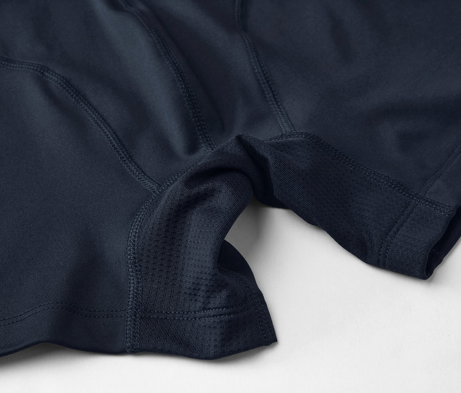 Nahaufnahme von marineblauer Sportunterwäsche mit Mesh-Einsätzen und Nähten auf hellem Hintergrund.