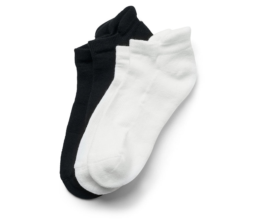 Nahaufnahme von einem Paar schwarzen und einem Paar weißen Socken.