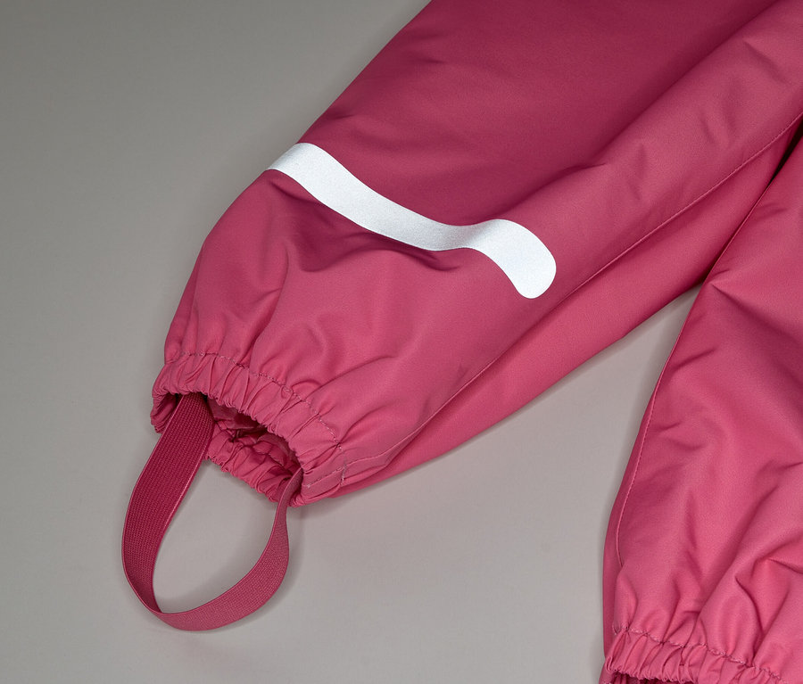Nahaufnahme eines rosafarbenen Overalls mit einem weißen reflektierenden Streifen am Ärmel und einem elastischen Fußband.