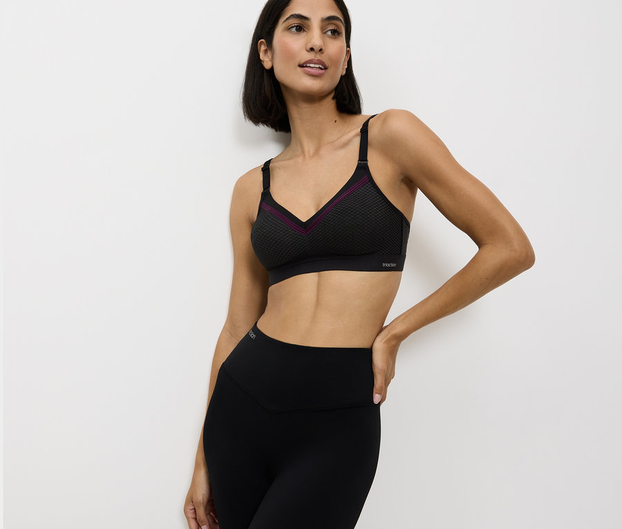 Frau trägt einen schwarzen Sport-BH und Leggings.