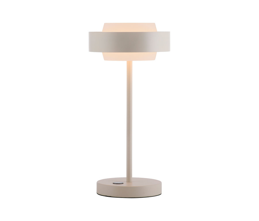 Eine hellbeige Tischlampe mit rundem Fuß, schlankem Stiel und geschichtetem Schirm. Der innere, durchscheinende Zylinder des Schirms leuchtet warm, umgeben von einem breiteren, undurchsichtigen Band. Ein kleiner Knopf ist am Fuß sichtbar.