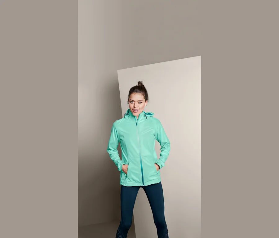 Frau posiert in leichter Softshelljacke.