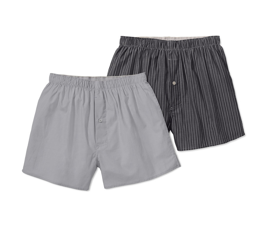 Zwei Webboxershorts, eine grau und eine grau gestreift.