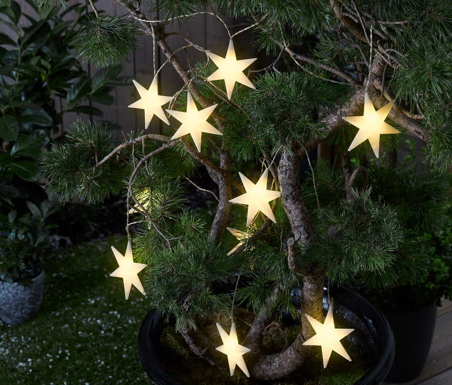 Ein Baum im Topf ist mit einer LED-Akku-Lichterkette »Sterne« geschmückt.