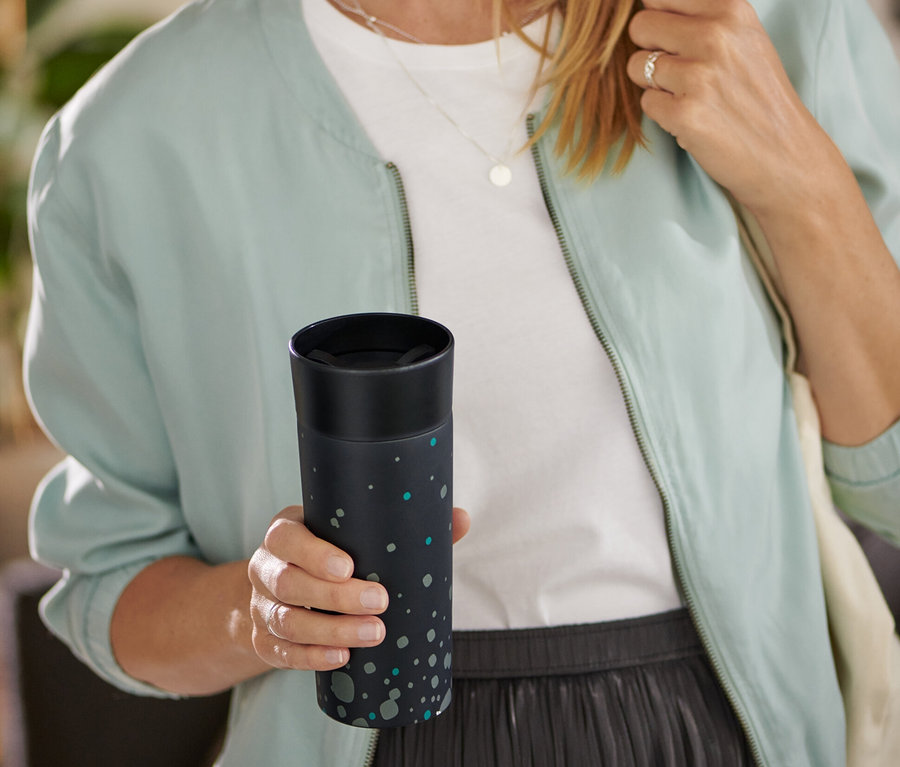 Frau hält Coffee-to-go-Becher, Hybrid Black.