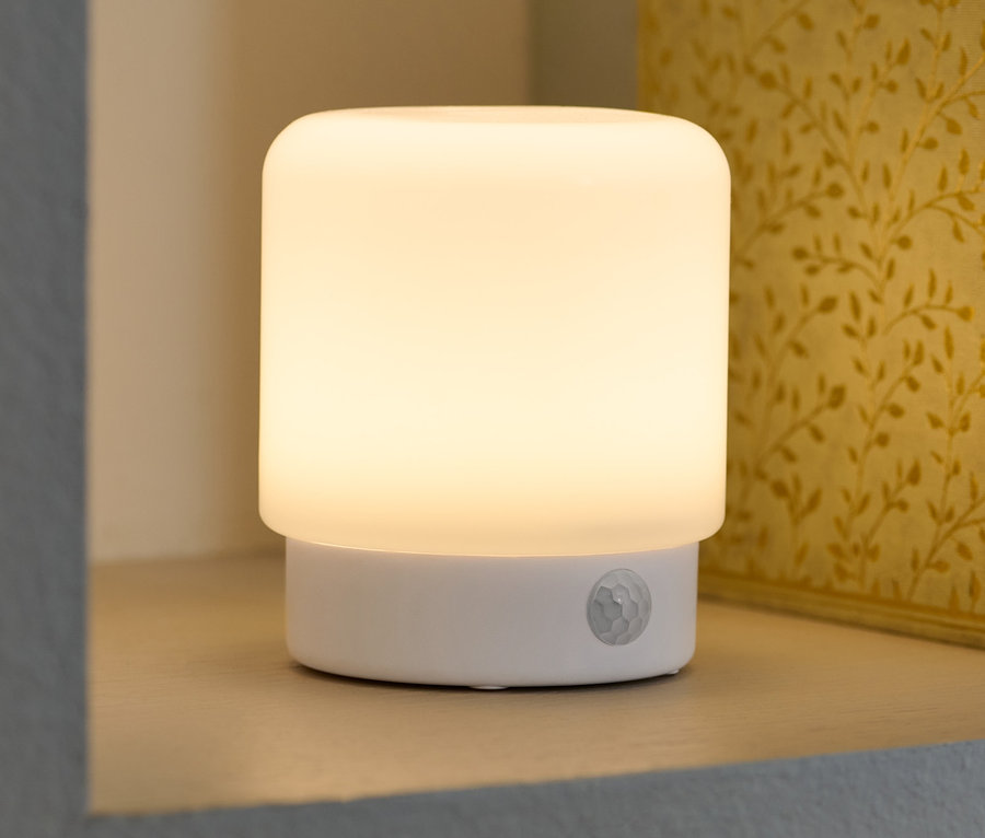 LED-Mini-Multifunktionslicht mit Bewegungsmelder steht in einem Regal neben Büchern.