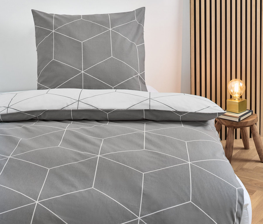 Graue Renforcé-Bettwäsche Normalgröße mit geometrischem Muster auf einem Bett.