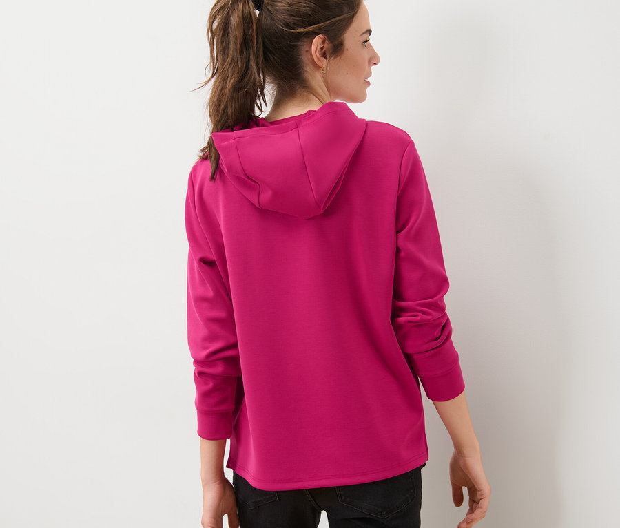 Eine Frau mit dem Rücken zur Kamera trägt einen pinken Hoodie aus Modal-Mix.