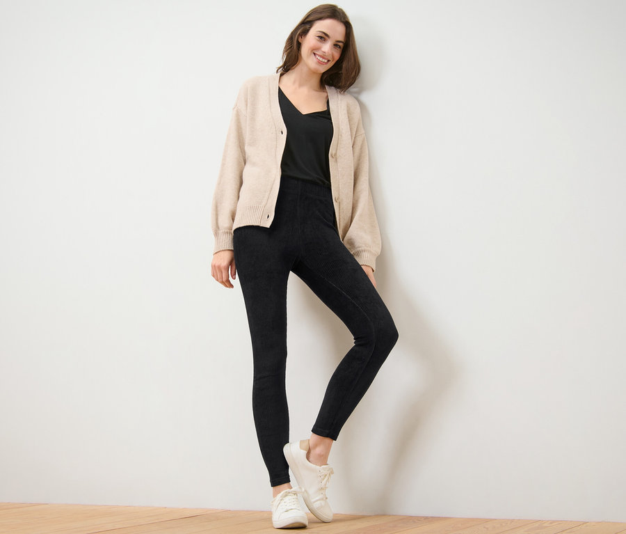 Frau posiert in schwarzen Cord-Leggings.