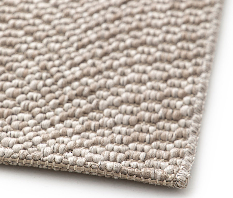Detailaufnahme einer Ecke des beigen Teppichs »Twine« mit natürlichem Muster.