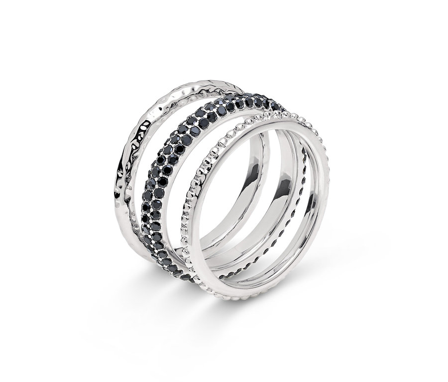 Detailaufnahme eines silbernen Rings mit vier Bändern, eines davon mit schwarzen Steinen.