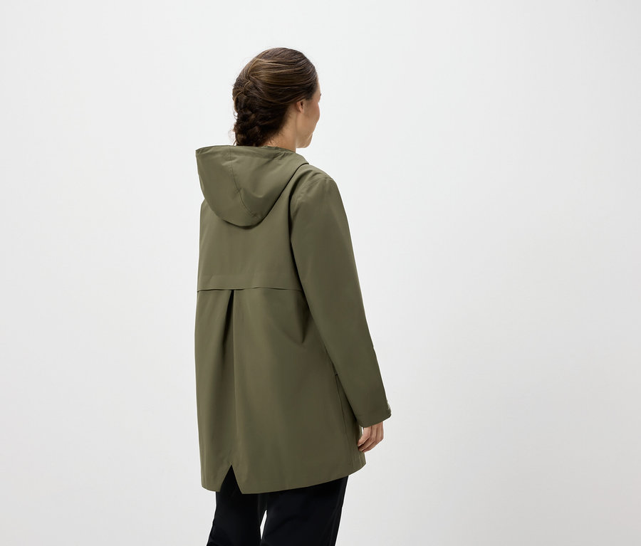 Frau von hinten trägt eine olivgrüne Kapuzenjacke und schwarze Hosen.