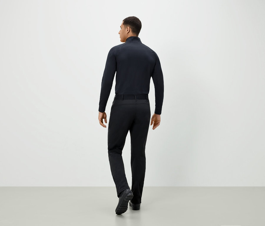 Mann in schwarzer Kleidung von hinten.