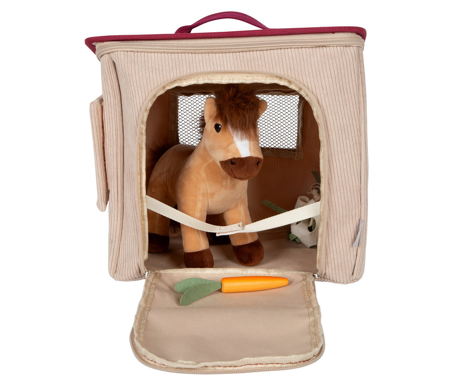Ein Stoffpferd steht im small foot Spiel-Set Pferd mit Stall, mit einer Karotte davor.