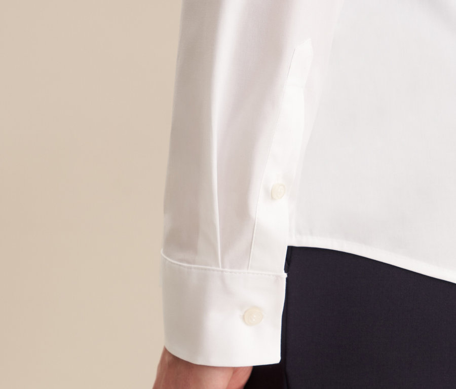 Detailansicht einer weißen Seidensticker Slimfit Bluse mit langem Ärmel und Manschette mit Knopf.