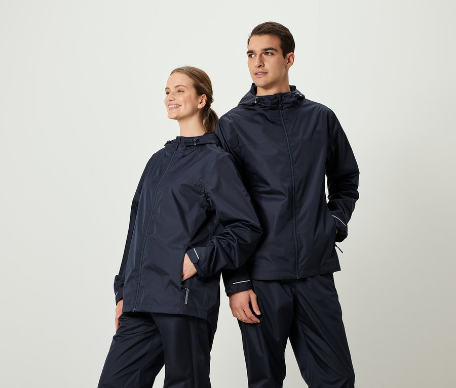 Zwei Personen posieren in passenden dunkelblauen Regenjacken und -hosen.