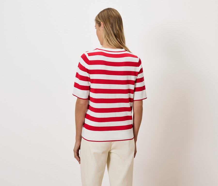 Frau mit dem Rücken zur Kamera trägt ein rot-weiß gestreiftes Oberteil.