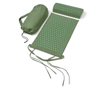 Eine grüne Akupressurmatte und ein Kissen neben einer grünen Tasche.