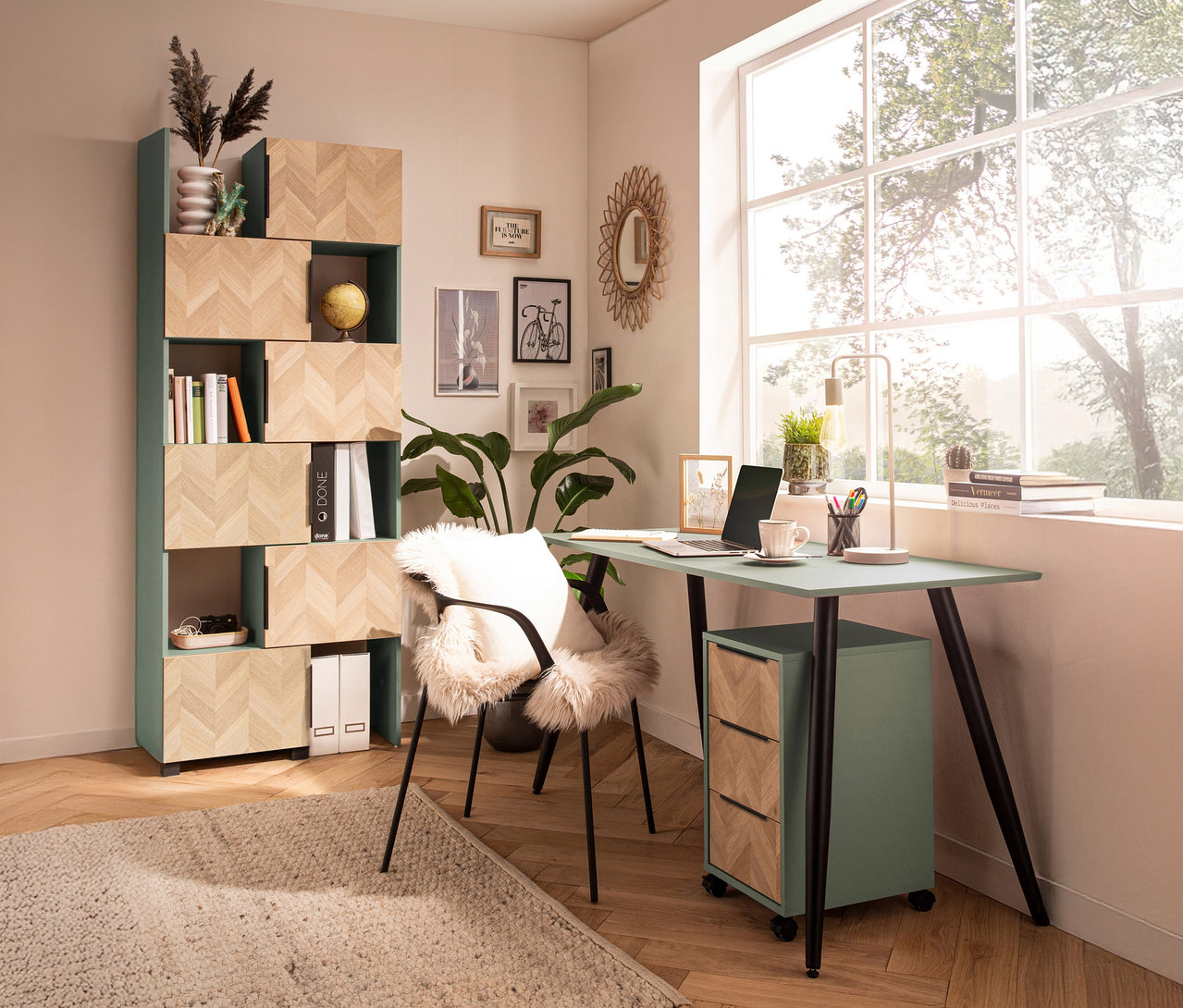 Ein Arbeitszimmer mit einem mintgrünen Schreibtisch, einem Bücherregal und einem Fenster.