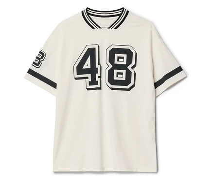 Ein cremefarbenes T-Shirt mit der schwarzen Zahl 48 auf der Vorderseite und der Zahl 3 auf dem Ärmel.