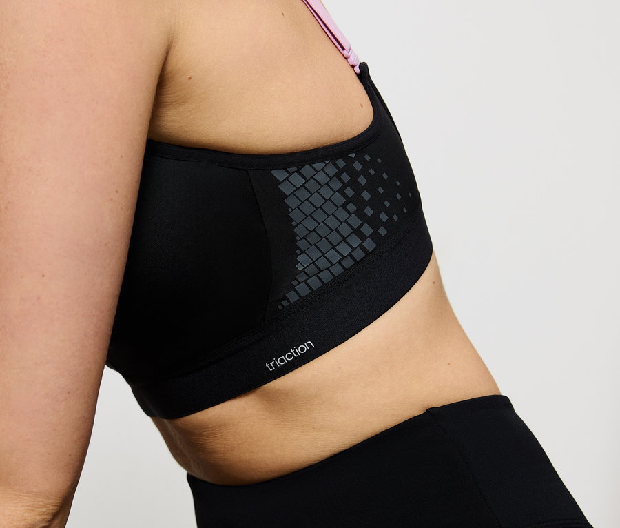 Nahaufnahme einer Frau, die einen schwarzen Triaction Sport-BH und Leggings trägt.