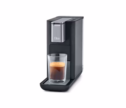 Qbo ESSENTIAL Dark Stone Kaffeemaschine mit Tasse Kaffee.