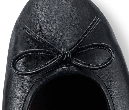 Detailaufnahme eines Leder-Ballerinas mit Schleife.