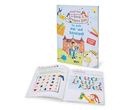 Das Buch »Die Schule der magischen Tiere – der große Mal- und Rätselspaß« steht aufrecht und zeigt sein Cover mit einer Schule, Kindern und Tieren. Davor liegt ein offenes Buch mit einer Gitterrätselseite und einer Illustration eines Mädchens, das bunte Socken aufhängt.