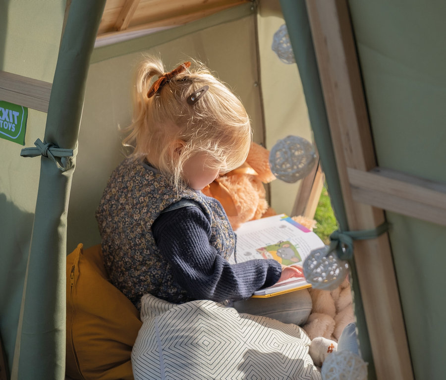 Mädchen liest ein Buch im EXIT Spielhaus "Yuki 100".
