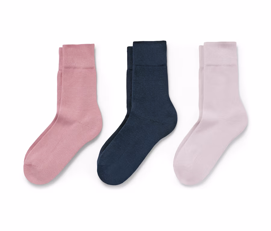 Drei Paar Socken in rosa, dunkelblau und hellrosa liegen auf einem weißen Hintergrund.