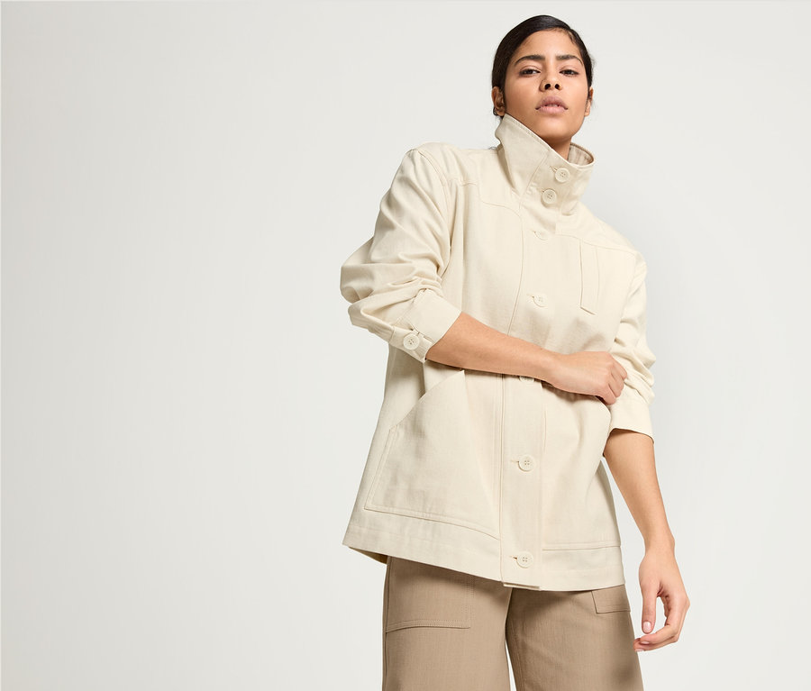 Frau posiert in NAH/STUDIO Parka aus ungefärbter Baumwolle, NAH/STUDIO Culotte aus recycelter Baumwolle und NAH/STUDIO T-Shirt in Ocean Blue.