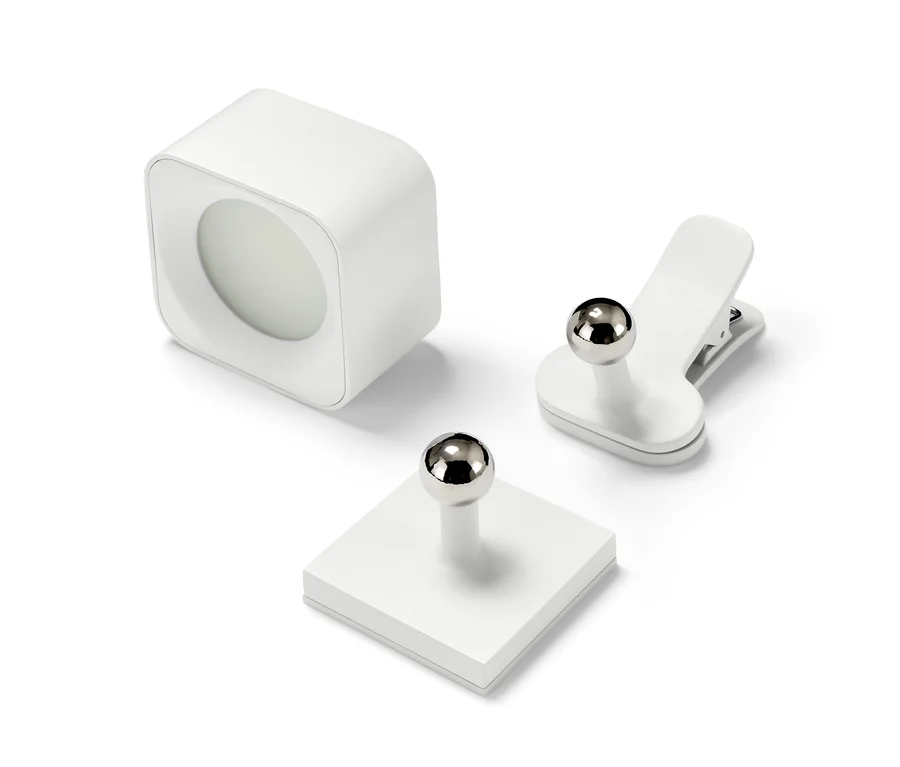 Eine LED-Akku-Wandleuchte, eine Magnethalterung und eine Klammer auf weißem Hintergrund.